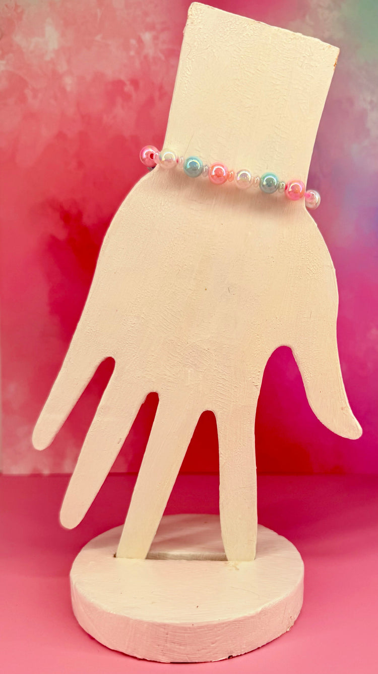 Bracelet with sprinkle-patterned bead and pink pearls on white hand display