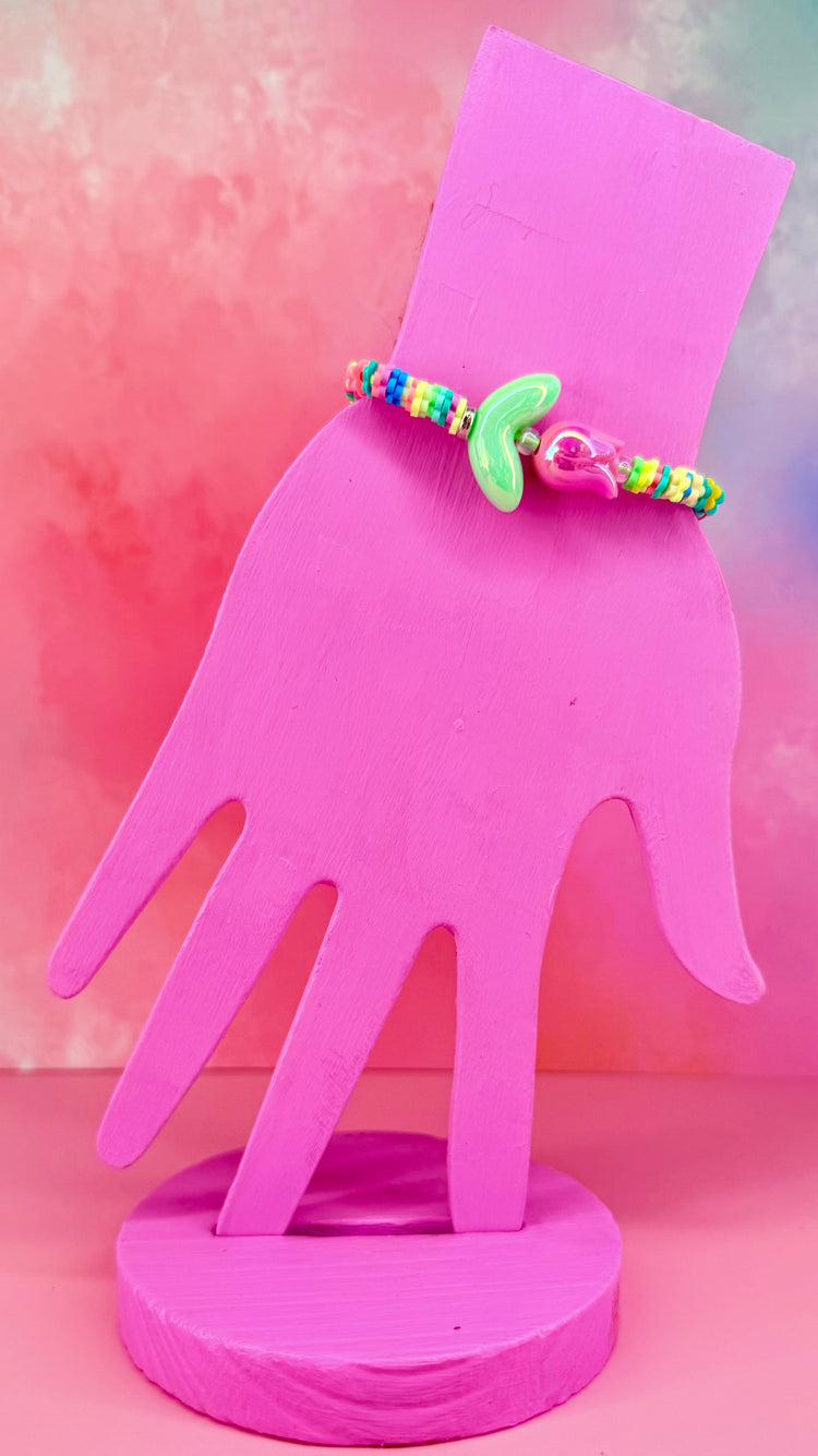Colorful beaded bracelet with tulip charm on a pink hand display