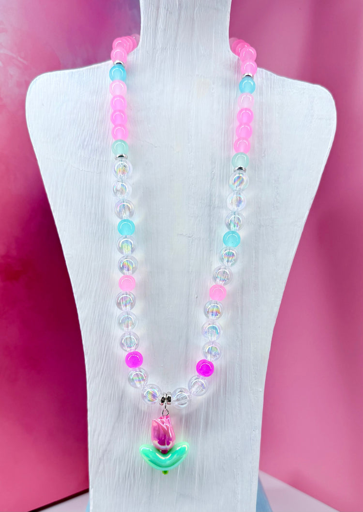 Necklace with tulip charm and pastel beads on white display bust
