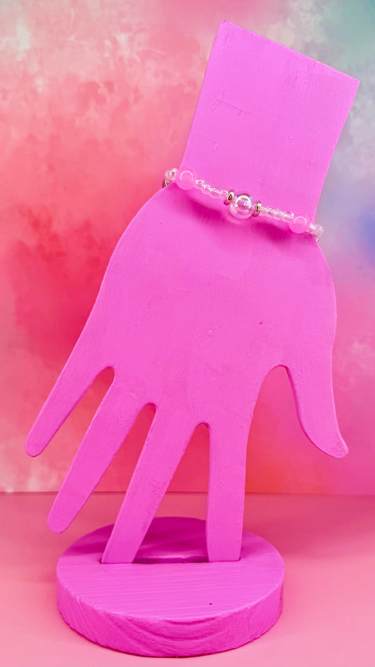 Colorful seed bead bracelet with irregular shapes on pink hand display