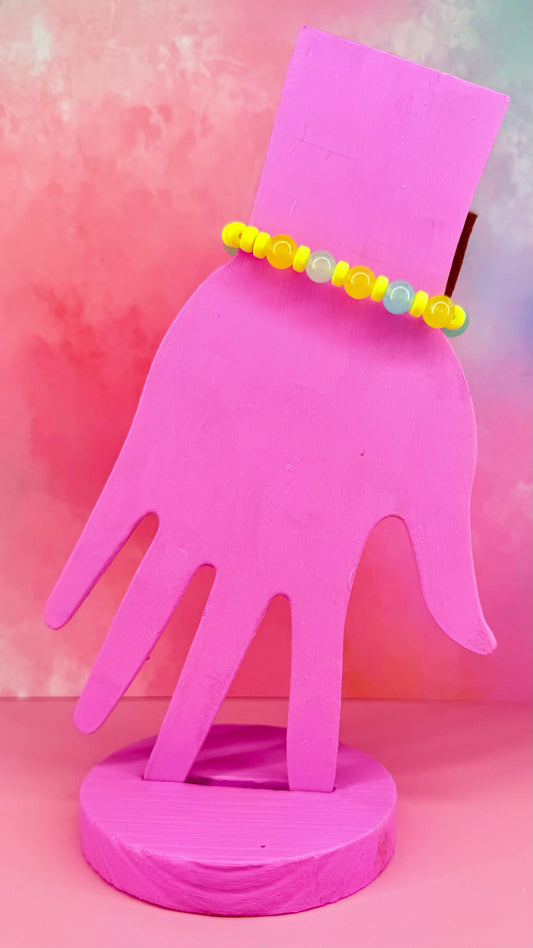 Bracelet with yellow translucent beads on pink hand display