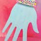 Stacked pastel bracelets with beaded words like GRLPWR, LOVED, and HAPPY on blue display hand