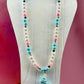 Pastel beaded necklace with unicorn charm on a white bust display